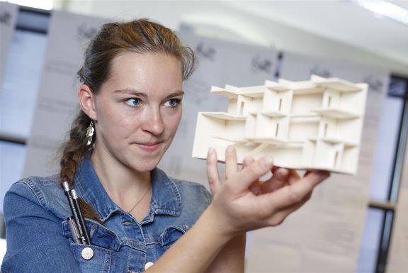 Forschung Fachhochschule Kärnten - FuCoSo zeigt eine Studentin, die ein Model aus Holz betrachtet.