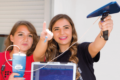 Das Imagefoto von IRaT zeigt zwei Studentinnen mit technischer Ausstattung.
