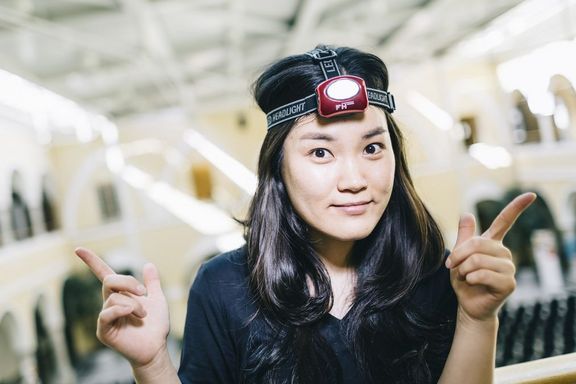 Das Imagefoto von FFG Talente Praktika zeigt eine junge Studentin mit einer Stirnlampe, die mit ihren Zeigefingern nach links und rechts zeigt.