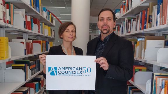 Svetlana Buko and Bernhard Guetz holding an American Councils Poster 